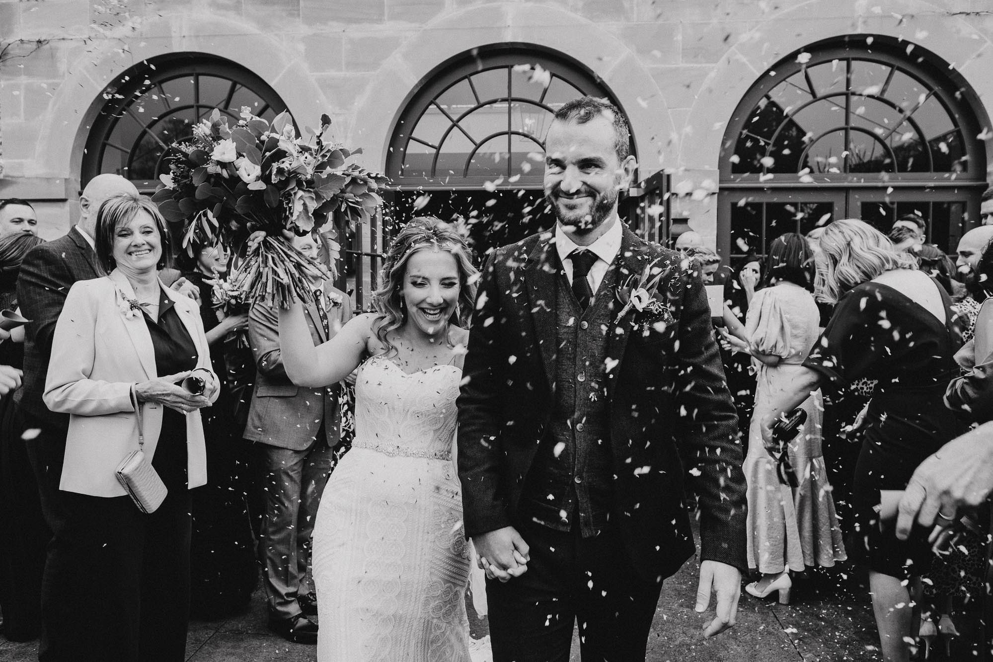 Bride and groom confetti outside the Fig House Middleton Lodge